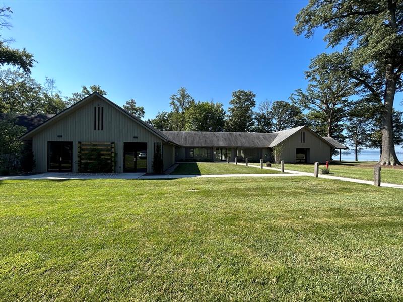 Point of View's primary building with grass, trees, and the water in the distance.